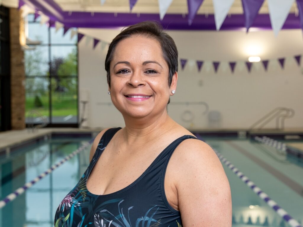 Woman smiling in front of a swimming pool