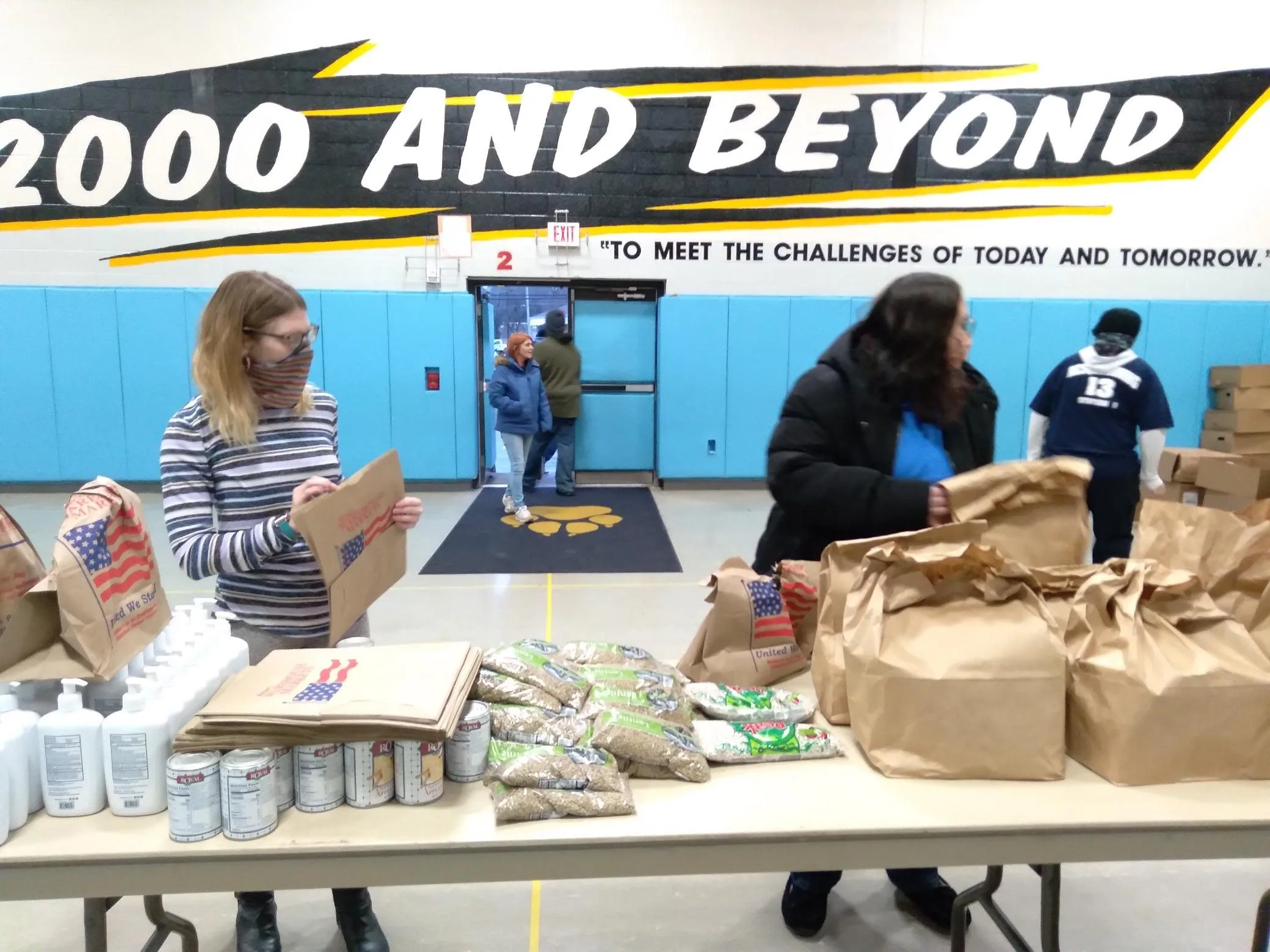Volunteers serving bags of food