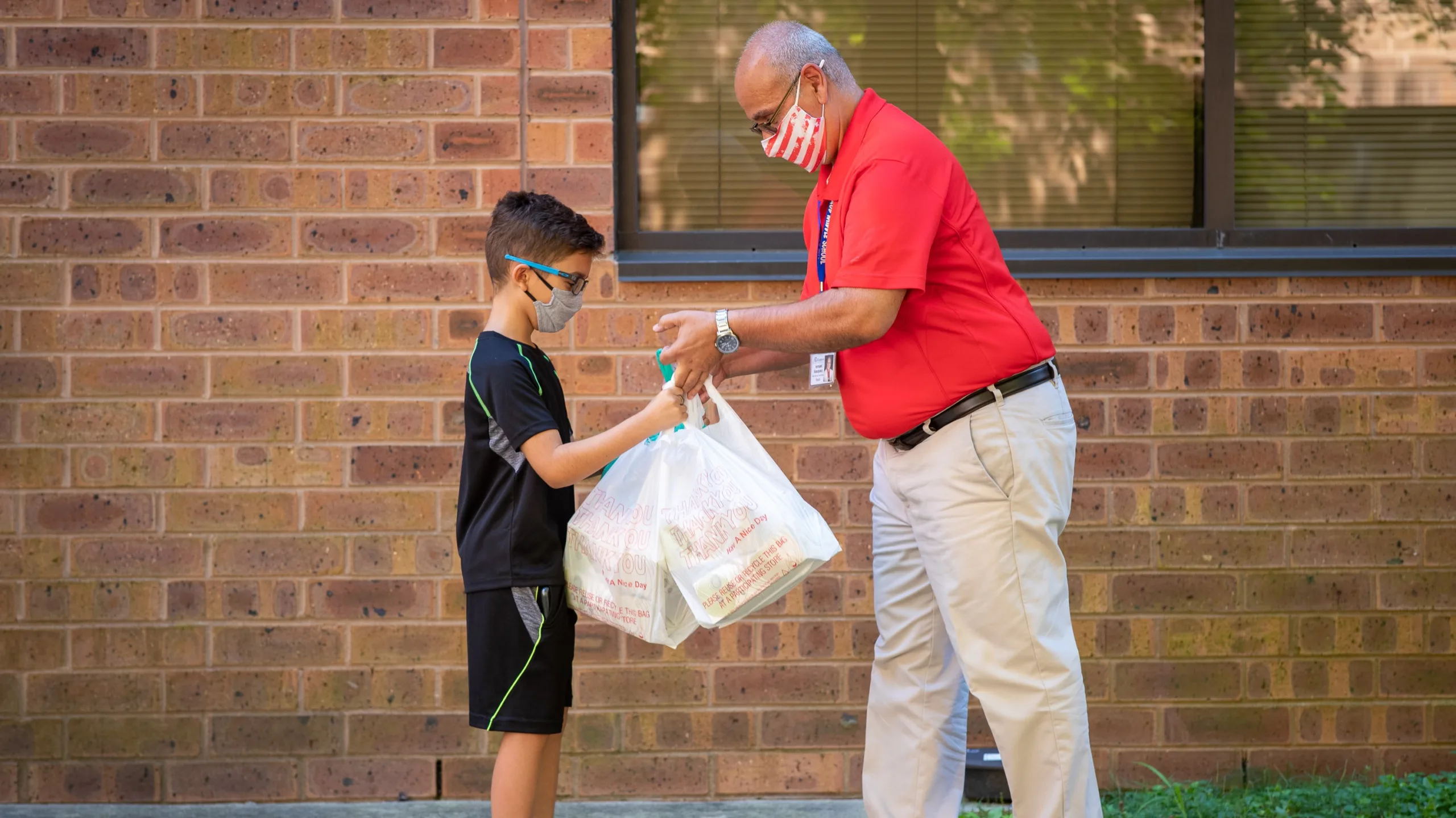 child receiving grocery bag from an adult