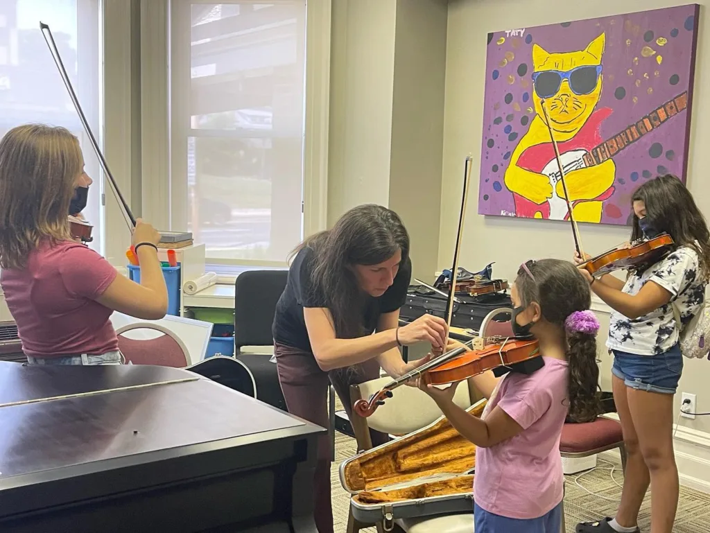 Children learning how to play the violin at Fine Feather Foundation's summer program