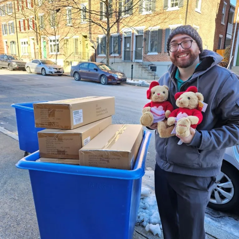 Man holding 2 donated Godiva Teddy Bears