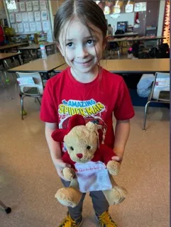 Child from Donegan Elementary School in Bethlehem holding donated a Godiva teddy bear