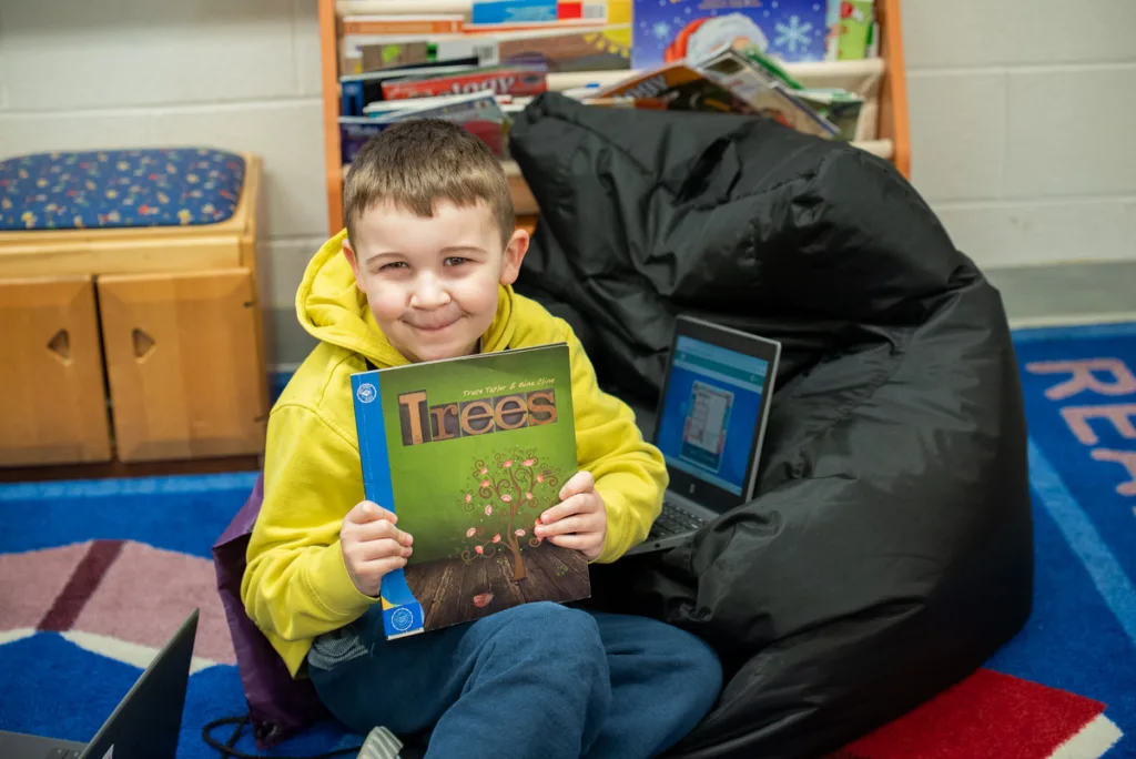 child smiling holding a book