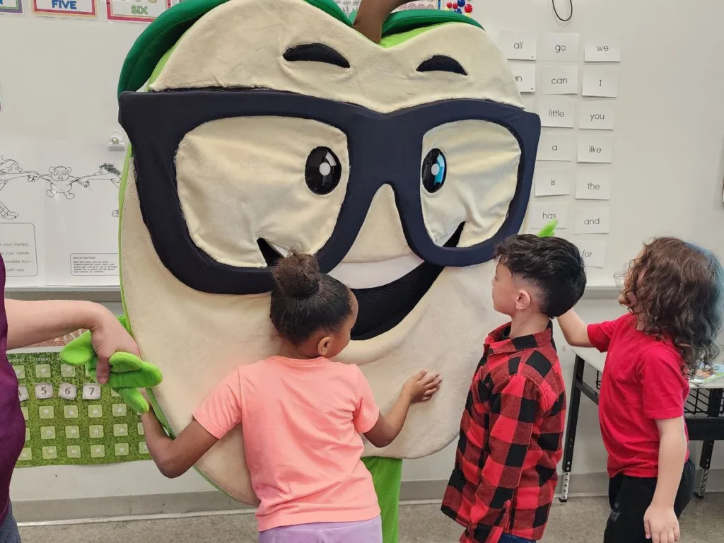 Children hug Corey the Apple